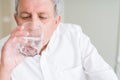 Handsome senior man drinking a fresh glass of water at home Royalty Free Stock Photo