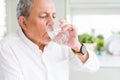 Handsome senior man drinking a fresh glass of water at home Royalty Free Stock Photo