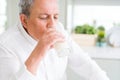 Handsome senior man drinking a glass of fresh milk in the morning Royalty Free Stock Photo