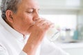 Handsome senior man drinking a glass of fresh milk in the morning Royalty Free Stock Photo