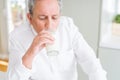 Handsome senior man drinking a glass of fresh milk in the morning Royalty Free Stock Photo