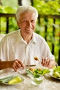 Handsome senior man eating healthy breakfast outdoors Royalty Free Stock Photo