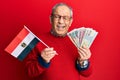 Handsome senior man with grey hair holding egypt flag and egyptian pounds banknotes winking looking at the camera with sexy Royalty Free Stock Photo
