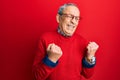 Handsome senior man with grey hair wearing casual clothes and glasses excited for success with arms raised and eyes closed Royalty Free Stock Photo
