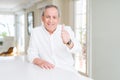 Handsome senior man at home doing happy thumbs up gesture with hand Royalty Free Stock Photo