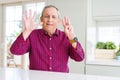Handsome senior man at home showing and pointing up with fingers number eight while smiling confident and happy Royalty Free Stock Photo