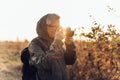 Handsome senior man photographer standing in autumn park and taking pictures with camera Royalty Free Stock Photo