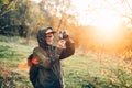 Handsome senior man photographer standing in autumn park and taking pictures with camera Royalty Free Stock Photo