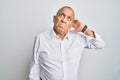 Handsome senior man wearing casual white shirt confuse and wondering about question Royalty Free Stock Photo