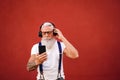 Handsome senior man with white beard, mustache and tattoos listening to music with headphones and mobile phone. Concept of elderly Royalty Free Stock Photo