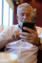 Handsome senior tourist man relaxing inside the coffee shop Royalty Free Stock Photo