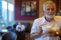 Handsome senior tourist man relaxing inside the coffee shop Royalty Free Stock Photo