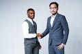 Handsome serious african american and asian businessmen agree to a contract shaking hands and looking at the camera Royalty Free Stock Photo