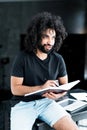 Handsome serious african american man with afro hairstyle holding a notebook in his hands and writes in it Royalty Free Stock Photo