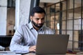 Concentrated ethnic Hispanic businessman working in office desk using laptop. Royalty Free Stock Photo