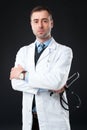 Handsome Serious male doctor holds stethoscope Royalty Free Stock Photo