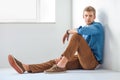 Handsome serious man sitting on the floor