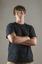 Handsome serious teenage boy in black shirt, arms crossed Royalty Free Stock Photo