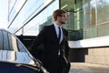 Handsome serious young businessman standing near his comfortable new car and going to the office Royalty Free Stock Photo