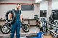 Service worker with motorcycle tire in the workshop Royalty Free Stock Photo