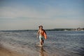 Handsome beach lifeguard running along the river bank with Royalty Free Stock Photo