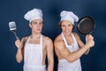 Two handsome chefs with apron on naked muscular body with kitchen utensils on blue background