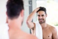 Handsome shirtless man looking in the mirror