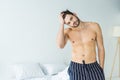 handsome shirtless man posing in bedroom