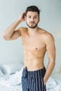 handsome shirtless man standing in bedroom Royalty Free Stock Photo