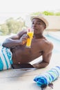 Handsome shirtless man using tablet pc poolside drinking cocktail Royalty Free Stock Photo