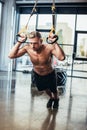 handsome shirtless sportsman exercising with resistance bands