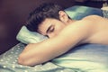 Handsome shirtless young man sleeping in bed