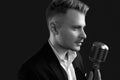 Handsome singer in elegant tuxedo and bow tie with vintage microphone