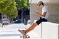 Handsome skater boy using his mobile phone in the street. Royalty Free Stock Photo