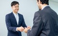 Handsome smart formal Asian businessman wearing suit, cheerful happy smiling with confidence, standing in modern office and Royalty Free Stock Photo