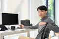 Handsome Asian male graphic designer or program developer sits at his desk in modern office Royalty Free Stock Photo