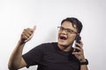 Handsome smart Asian young man calling by smartphone with agreeing expression on white background