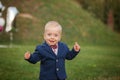 Handsome smile portrait baby. 1 year old cute boy on the grass. Birthday anniversary.