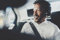 Handsome smiling african man listening music on smartphone while sitting on backseat in taxi car.Concept of happy young Royalty Free Stock Photo