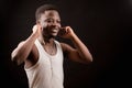 Handsome smiling Afro man putting on earphones.music fan.have a rest. Royalty Free Stock Photo