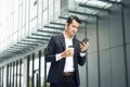 Handsome smiling asian businessman holding smartphone in office Businessman Royalty Free Stock Photo