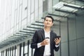 Handsome smiling asian businessman holding smartphone in office Businessman Royalty Free Stock Photo