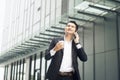 Handsome smiling asian businessman holding smartphone in office Businessman Royalty Free Stock Photo