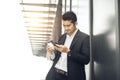 Handsome smiling asian businessman holding smartphone in office Businessman Royalty Free Stock Photo