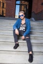 Handsome blond young man in blue sunglasses, sitting on stair st Royalty Free Stock Photo