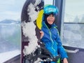 Smiling boy with snowboard stand in the cabin of a chairlift Royalty Free Stock Photo