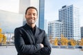 Handsome smiling businessman portrait with arms crossed wearing suite with financial district city in the background Royalty Free Stock Photo