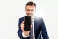 Handsome smiling businessman showing phone with blank black screen to the camera. Man holding smart mobile cell phone in hand Royalty Free Stock Photo