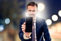 Handsome smiling businessman showing phone with blank black screen to the camera. Man holding smart mobile cell phone in hand Royalty Free Stock Photo