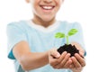 Handsome smiling child boy holding soil growing green sprout leaf